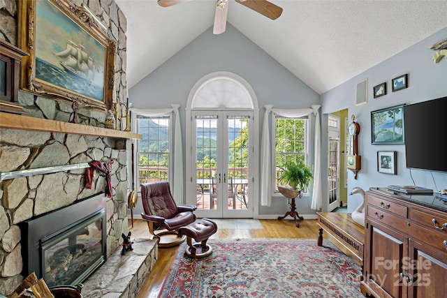 65 Timber Park Dr, Black Mountain, NC 28711 - living area featuring light wood finished floors, french doors, ceiling fan, a stone fireplace, and beam ceiling