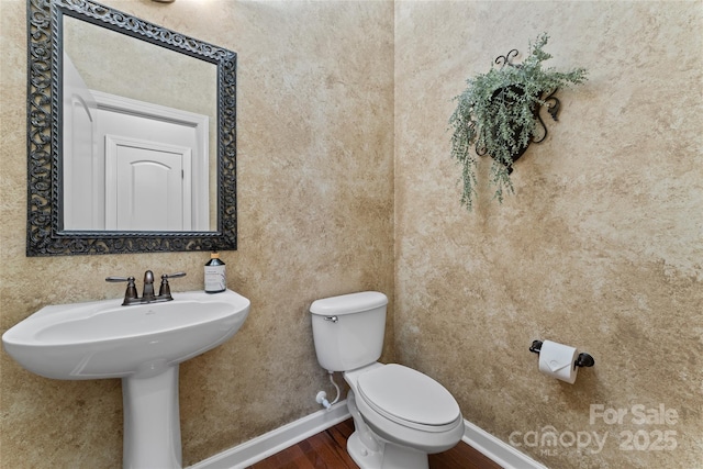 10620 Euclid Ave NW, Concord, NC 28027 - bathroom featuring wood finished floors, toilet, baseboards, and a sink
