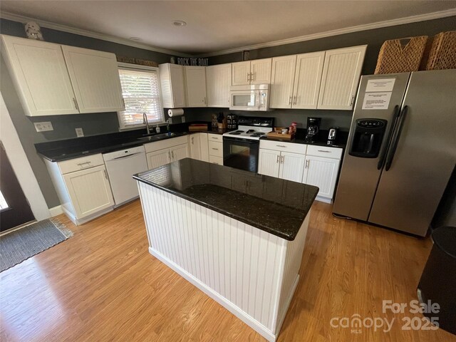 132 Marina Ln, Mooresville, NC 28117 - kitchen featuring white appliances, ornamental molding, dark countertops, light wood-style floors, and white cabinetry