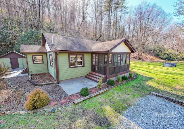 7150 Yellow Creek Rd, Robbinsville, NC 28771 - single story home featuring a sunroom, a front yard, a shingled roof, and a patio