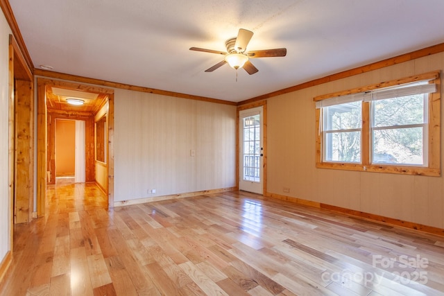 7150 Yellow Creek Rd, Robbinsville, NC 28771 - spare room featuring light wood-type flooring, a ceiling fan, ornamental molding, baseboards, and wood walls