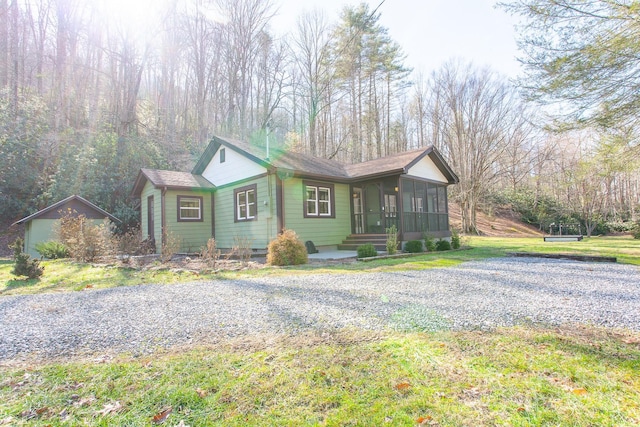 7150 Yellow Creek Rd, Robbinsville, NC 28771 - ranch-style home with a sunroom, a front lawn, and a shingled roof
