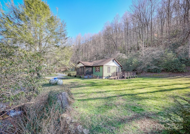 7150 Yellow Creek Rd, Robbinsville, NC 28771 - view of green lawn with a wooden deck, a wooded view, and a sunroom