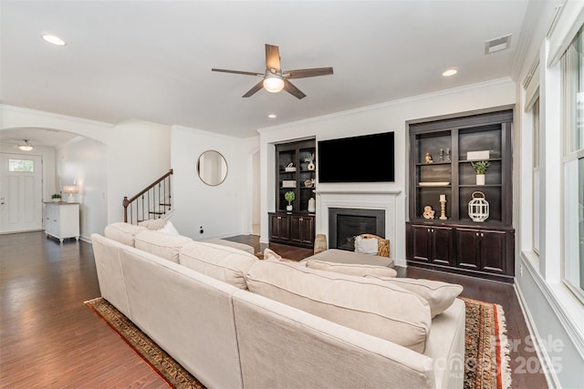 755 Lagan Ct, Fort Mill, SC 29715 - living room featuring ceiling fan, arched walkways, dark wood-type flooring, a glass covered fireplace, and ornamental molding