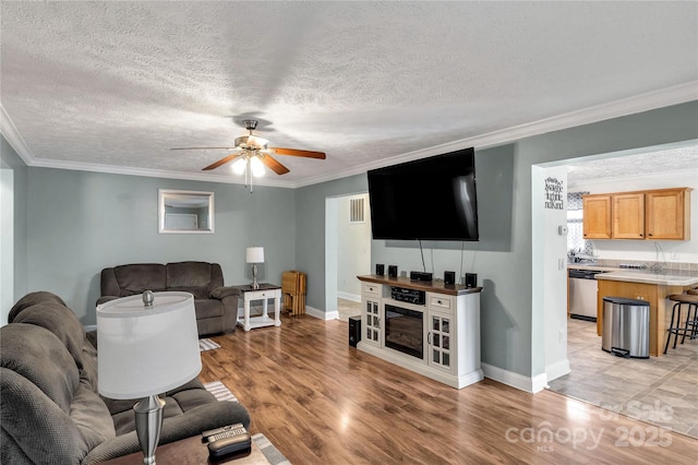 4285 Palmer Lloyd Rd, Lancaster, SC 29720 - living room with ceiling fan, crown molding, light wood-style floors, baseboards, and a textured ceiling