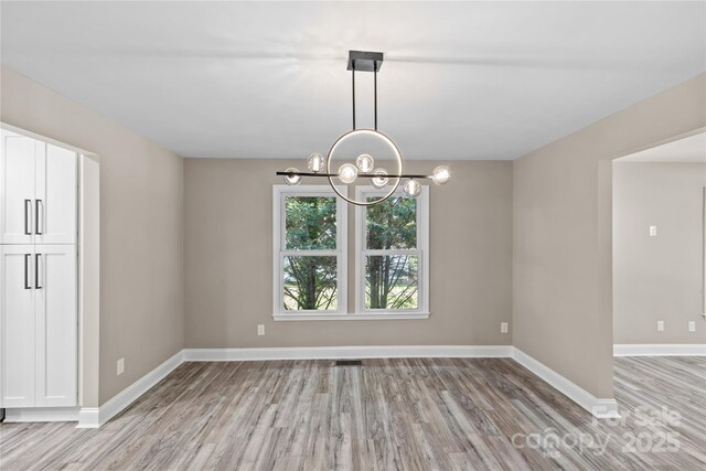 933 Old Charlotte Rd, Concord, NC 28027 - empty room with light wood-style flooring, a chandelier, and baseboards