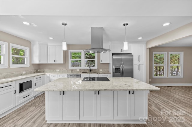 933 Old Charlotte Rd, Concord, NC 28027 - kitchen featuring stainless steel appliances, island exhaust hood, a sink, white cabinets, and a center island