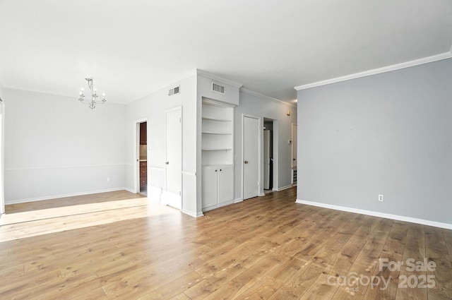 5947 Quail Hollow Rd Unit A, Charlotte, NC 28210 - spare room featuring a chandelier, ornamental molding, light wood-style flooring, and built in shelves