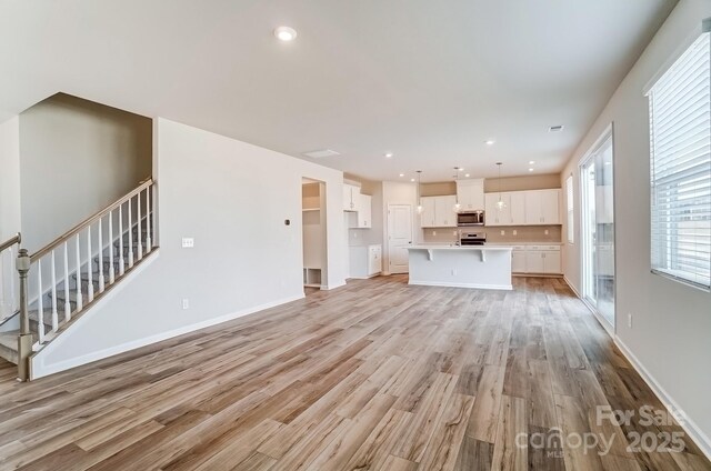 2648 Tillman St, Monroe, NC 28112 - unfurnished living room featuring light wood finished floors, baseboards, recessed lighting, and stairs