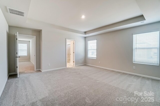 2648 Tillman St, Monroe, NC 28112 - unfurnished bedroom with a raised ceiling, light colored carpet, and baseboards