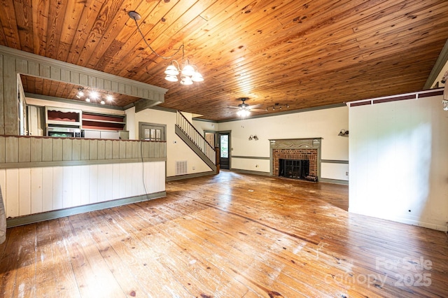 809 Westminster Cir SW, Lenoir, NC 28645 - unfurnished living room featuring wood ceiling, hardwood / wood-style floors, a brick fireplace, stairway, and a chandelier