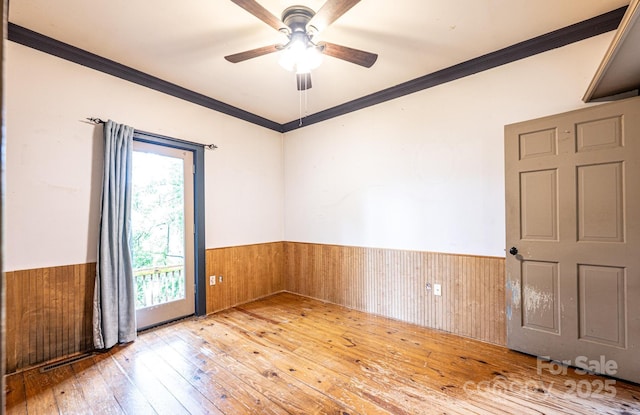 809 Westminster Cir SW, Lenoir, NC 28645 - empty room with wainscoting, ornamental molding, hardwood / wood-style flooring, ceiling fan, and wooden walls