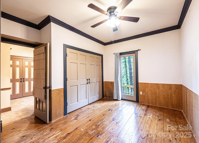809 Westminster Cir SW, Lenoir, NC 28645 - unfurnished bedroom featuring a wainscoted wall, wood-type flooring, ornamental molding, french doors, and wooden walls