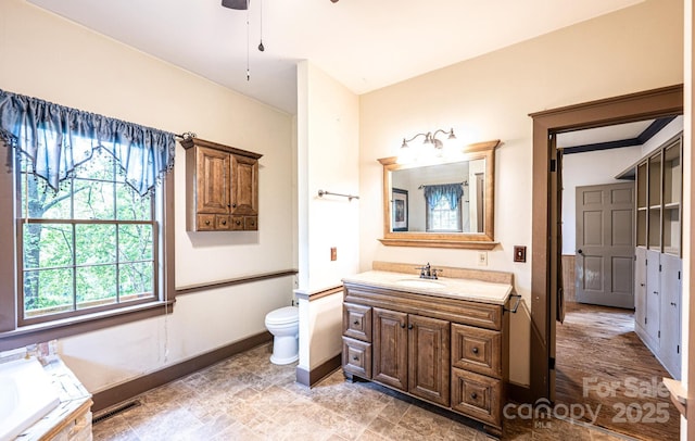 809 Westminster Cir SW, Lenoir, NC 28645 - full bath featuring vanity, baseboards, a bath, toilet, and ceiling fan
