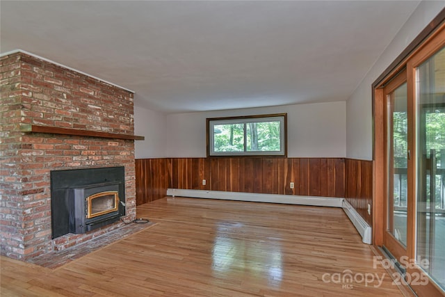 5 Old Cove Rd, Black Mountain, NC 28711 - unfurnished living room with hardwood / wood-style floors, wainscoting, wood walls, and a brick fireplace