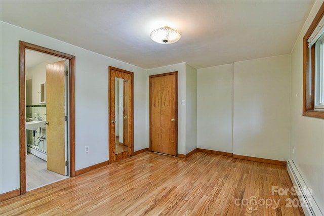 5 Old Cove Rd, Black Mountain, NC 28711 - unfurnished bedroom featuring a baseboard heating unit, light wood-style floors, and baseboards
