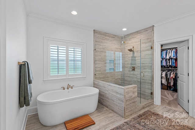 224 Hidden Meadows Dr, Mooresville, NC 28117 - bathroom featuring a shower stall, a freestanding tub, ornamental molding, a spacious closet, and baseboards