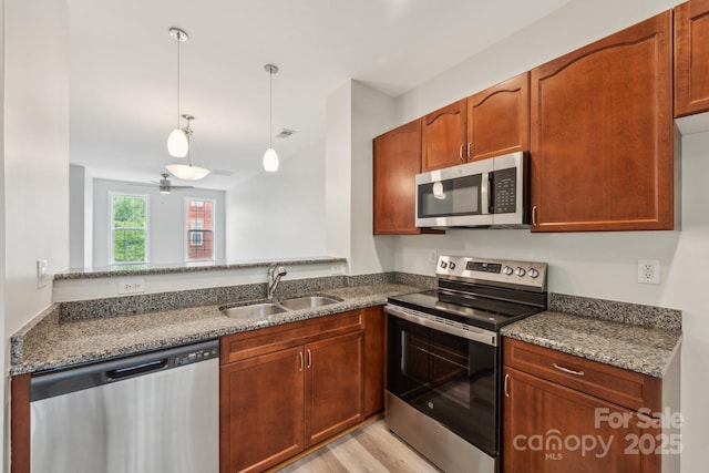 1126 Dean Hall Ln, Matthews, NC 28105 - kitchen featuring appliances with stainless steel finishes, a sink, pendant lighting, a ceiling fan, and dark stone counters