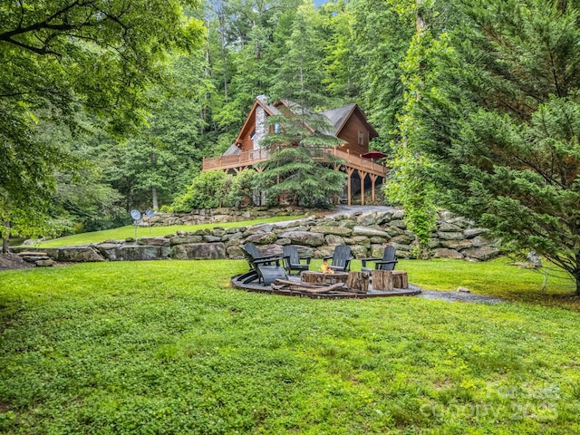 120 Rocky Mountain Dr, Lake Lure, NC 28746 - view of green lawn with an outdoor fire pit, a view of trees, and a deck