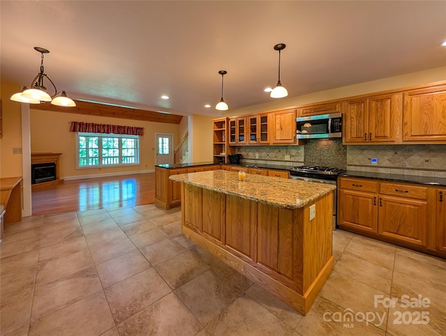 355 Rosewood Ln, Burnsville, NC 28714 - kitchen featuring appliances with stainless steel finishes, brown cabinets, tasteful backsplash, dark stone countertops, and recessed lighting