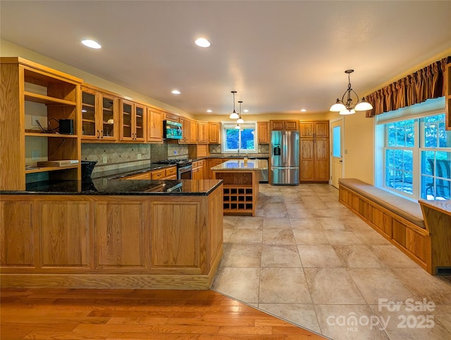 355 Rosewood Ln, Burnsville, NC 28714 - kitchen featuring stainless steel appliances, brown cabinetry, decorative backsplash, dark stone countertops, and recessed lighting