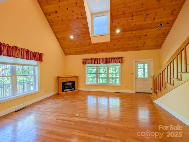 355 Rosewood Ln, Burnsville, NC 28714 - unfurnished living room featuring high vaulted ceiling, light wood-style floors, wooden ceiling, baseboards, and a glass covered fireplace