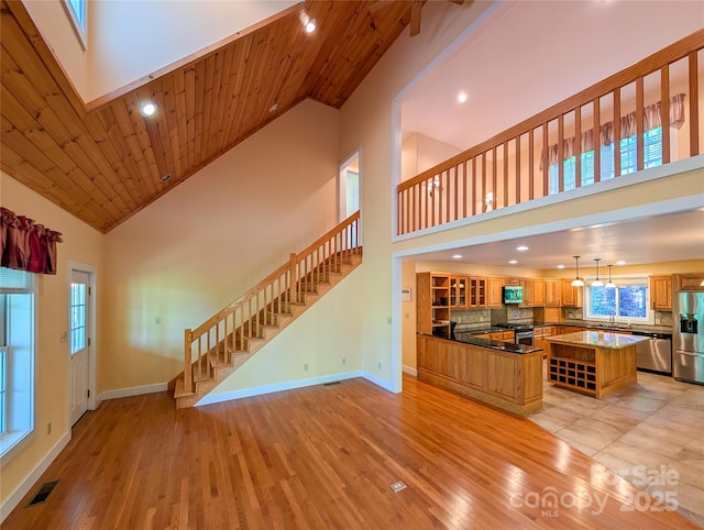 355 Rosewood Ln, Burnsville, NC 28714 - unfurnished living room featuring high vaulted ceiling, stairway, baseboards, light wood finished floors, and recessed lighting