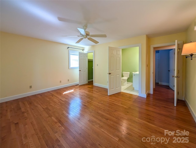 355 Rosewood Ln, Burnsville, NC 28714 - unfurnished bedroom featuring light wood-style floors, baseboards, connected bathroom, and ceiling fan