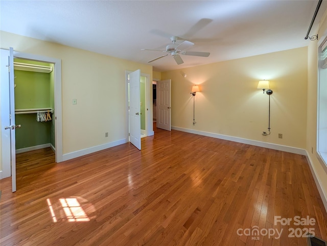 355 Rosewood Ln, Burnsville, NC 28714 - unfurnished bedroom featuring light wood-type flooring, baseboards, a ceiling fan, a walk in closet, and a closet