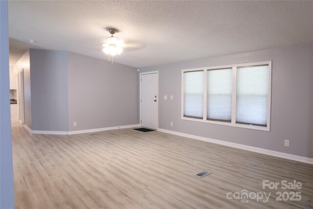 1184 Sherwood Rd, Clover, SC 29710 - unfurnished living room with a ceiling fan, a textured ceiling, wood finished floors, and baseboards