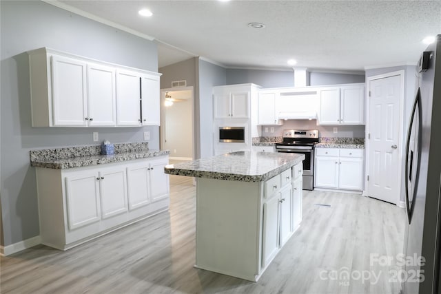 1184 Sherwood Rd, Clover, SC 29710 - kitchen with appliances with stainless steel finishes, under cabinet range hood, light wood finished floors, white cabinetry, and crown molding