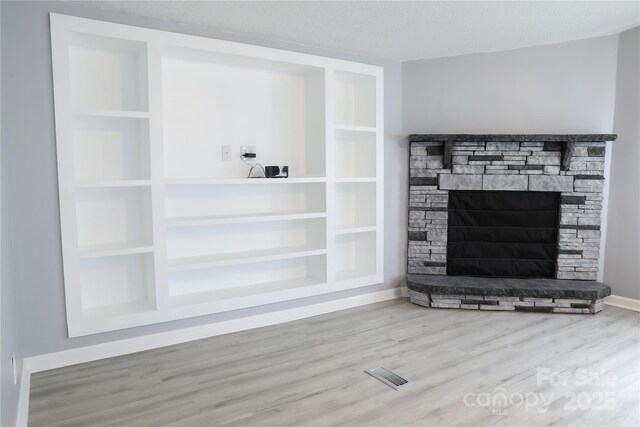 1184 Sherwood Rd, Clover, SC 29710 - unfurnished living room with wood finished floors, a fireplace, a textured ceiling, and baseboards