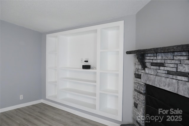 1184 Sherwood Rd, Clover, SC 29710 - detailed view of wood finished floors, a stone fireplace, a textured ceiling, and baseboards