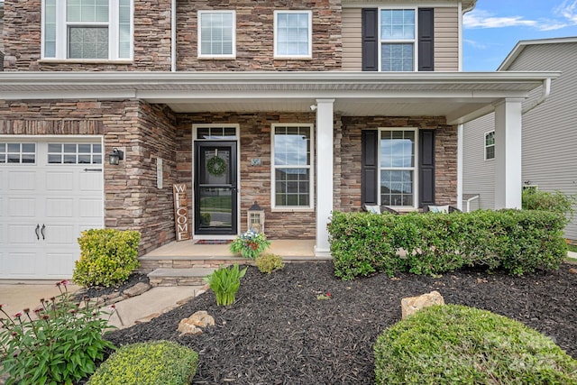7339 Millstone Cir SW, Concord, NC 28025 - view of exterior entry featuring covered porch, stone siding, and an attached garage