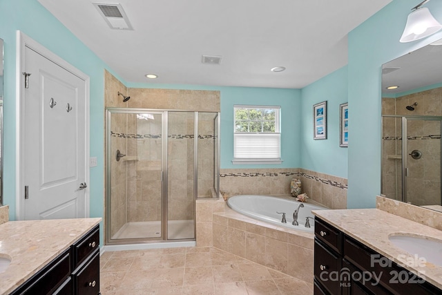 7339 Millstone Cir SW, Concord, NC 28025 - full bathroom with two vanities, a garden tub, a shower stall, and recessed lighting