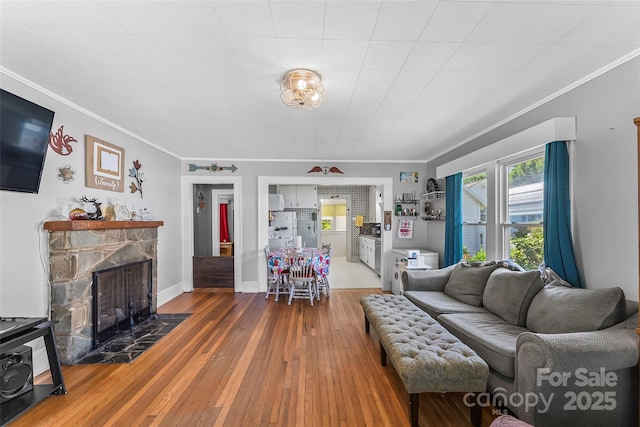 302 N St, Morganton, NC 28655 - living room featuring ornamental molding, a stone fireplace, wood-type flooring, healthy amount of natural light, and baseboards