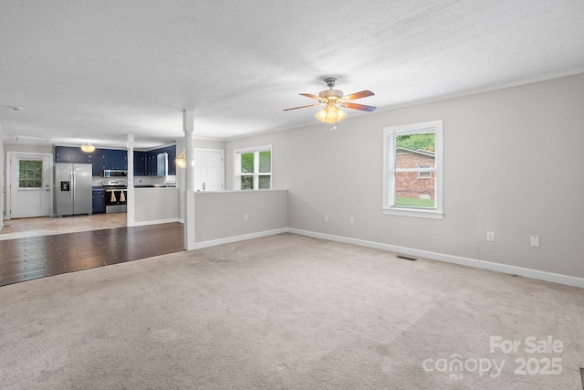 352 18th Ave NE, Hickory, NC 28601 - unfurnished living room with light carpet, healthy amount of natural light, ceiling fan, baseboards, and a textured ceiling