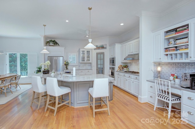 4323 Rosecliff Dr, Charlotte, NC 28277 - kitchen with stainless steel appliances, under cabinet range hood, tasteful backsplash, white cabinets, and crown molding