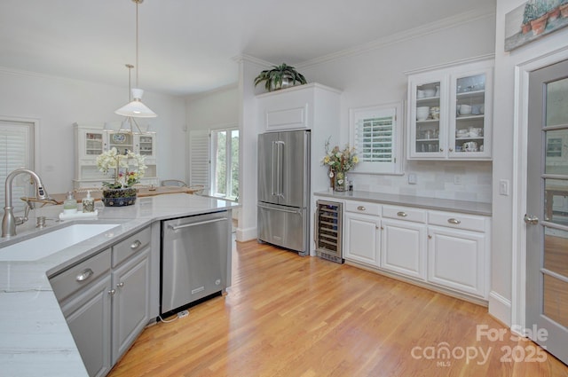 4323 Rosecliff Dr, Charlotte, NC 28277 - kitchen with stainless steel appliances, wine cooler, white cabinets, light wood finished floors, and glass insert cabinets