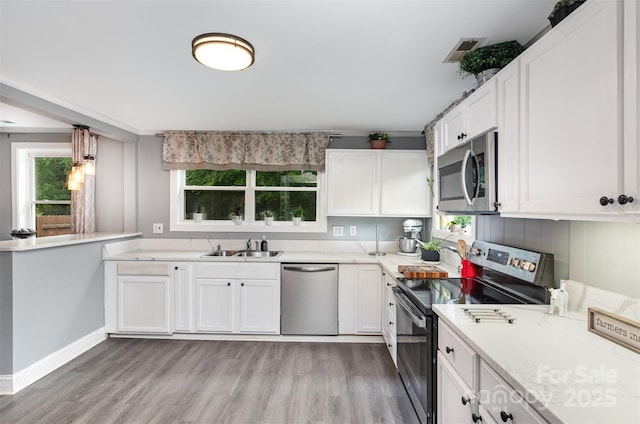 12504 Culp Rd, Gold Hill, NC 28071 - kitchen with appliances with stainless steel finishes, healthy amount of natural light, light wood-type flooring, and white cabinetry