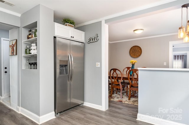 12504 Culp Rd, Gold Hill, NC 28071 - kitchen with stainless steel fridge with ice dispenser, crown molding, light wood finished floors, white cabinetry, and hanging light fixtures