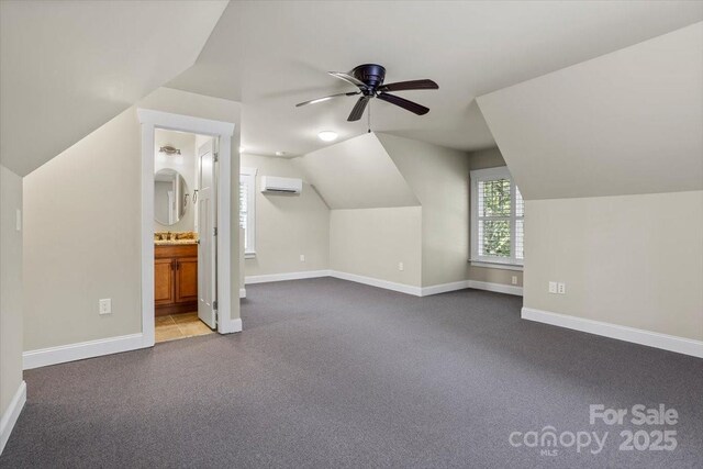 311 Carriage Crest Dr, Hendersonville, NC 28791 - additional living space featuring an AC wall unit, baseboards, vaulted ceiling, dark colored carpet, and ceiling fan