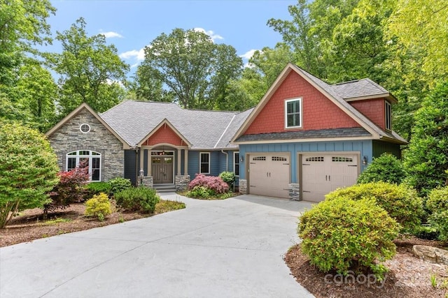 311 Carriage Crest Dr, Hendersonville, NC 28791 - craftsman-style house with stone siding, concrete driveway, board and batten siding, and an attached garage