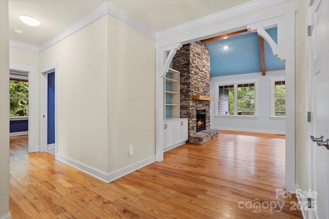 311 Carriage Crest Dr, Hendersonville, NC 28791 - unfurnished living room featuring light wood-style floors, ornamental molding, baseboards, a fireplace, and vaulted ceiling