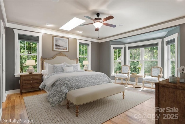 311 Carriage Crest Dr, Hendersonville, NC 28791 - bedroom featuring multiple windows, light wood finished floors, a skylight, and a ceiling fan