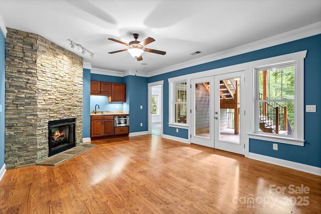311 Carriage Crest Dr, Hendersonville, NC 28791 - unfurnished living room featuring a sink, rail lighting, a ceiling fan, baseboards, and light wood-style floors