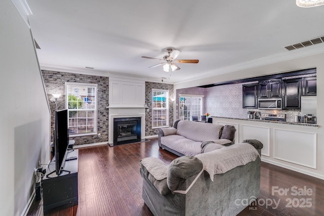 11714 Harsworth Ln, Charlotte, NC 28277 - living room featuring a ceiling fan, a fireplace with flush hearth, ornamental molding, and dark wood-style floors