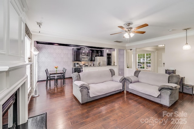 11714 Harsworth Ln, Charlotte, NC 28277 - living room with a fireplace with flush hearth, a ceiling fan, dark wood-type flooring, ornamental molding, and decorative columns