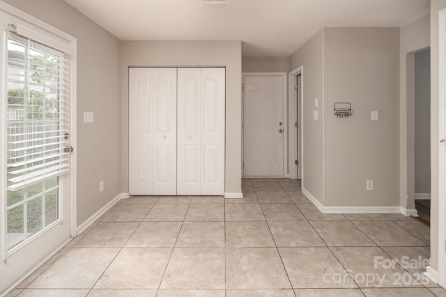 8432 Spirea Ct, Charlotte, NC 28215 - unfurnished bedroom with light tile patterned flooring, a closet, and baseboards