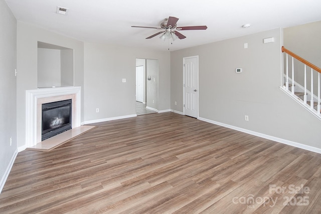 8432 Spirea Ct, Charlotte, NC 28215 - unfurnished living room with stairs, ceiling fan, wood finished floors, and baseboards